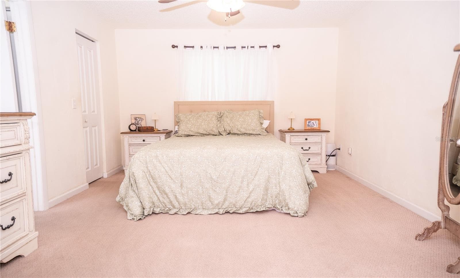 Beautiful primary bedroom featuring a spacious walk-in closet and a private ensuite bathroom off to the left. - 57 FORRESTER PL, PALM COAST