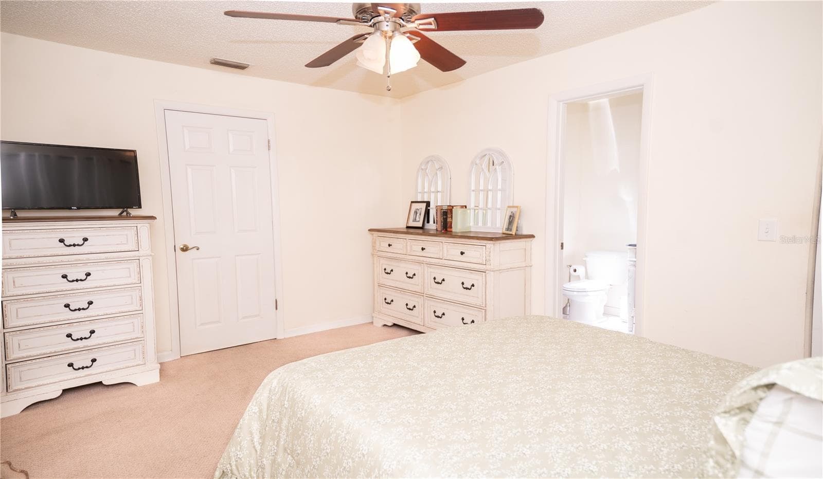 Primary bedroom featuring an ensuite bathroom with abundant natural light. - 57 FORRESTER PL, PALM COAST