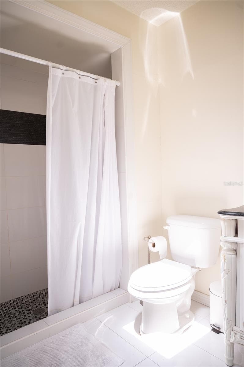 Ensuite primary bathroom featuring a spacious walk-in shower and private water closet. - 57 FORRESTER PL, PALM COAST