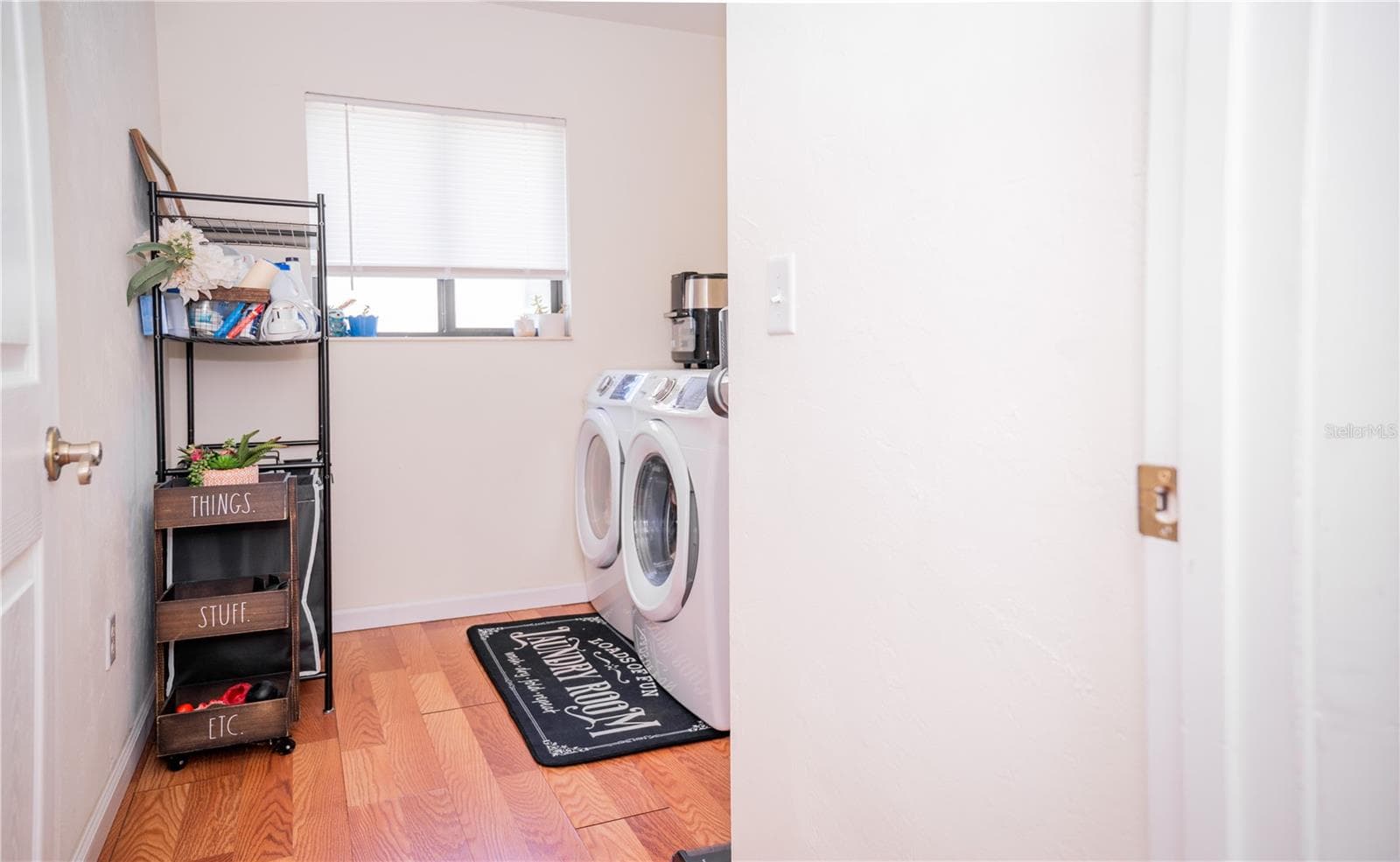 Bright, modern laundry room featuring a full-size washer and dryer with convenient storage space. - 57 FORRESTER PL, PALM COAST