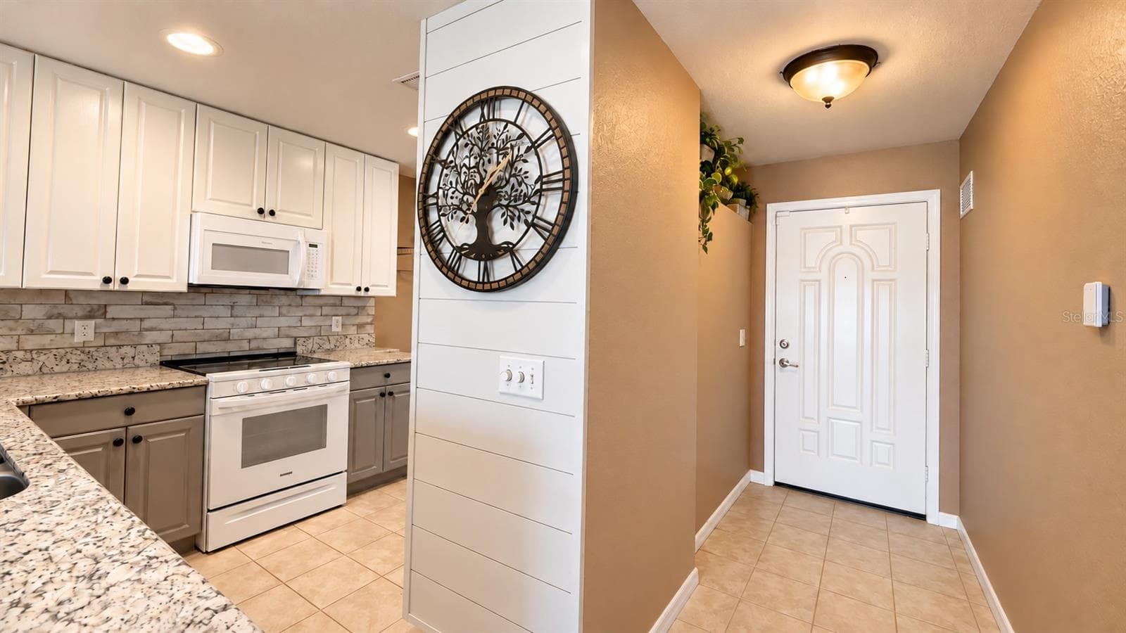 Modern two-toned kitchen, granite counters, shiplap decorative wall - 26397 NADIR RD #103, PUNTA GORDA