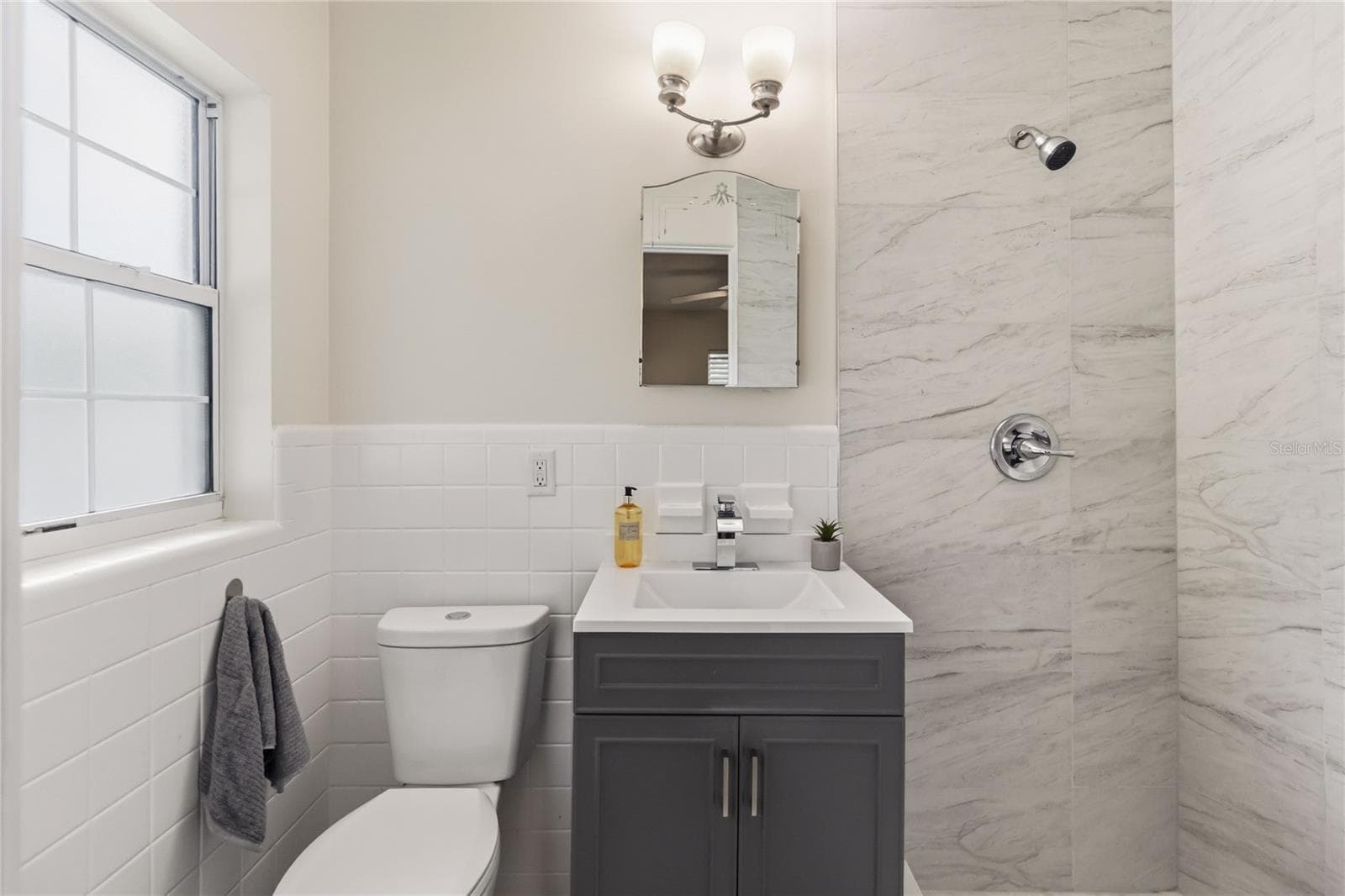 Primary ensuite has a nice Vanity, new light fixture new water storage with large shower - 7040 LAKE DR, ORLANDO