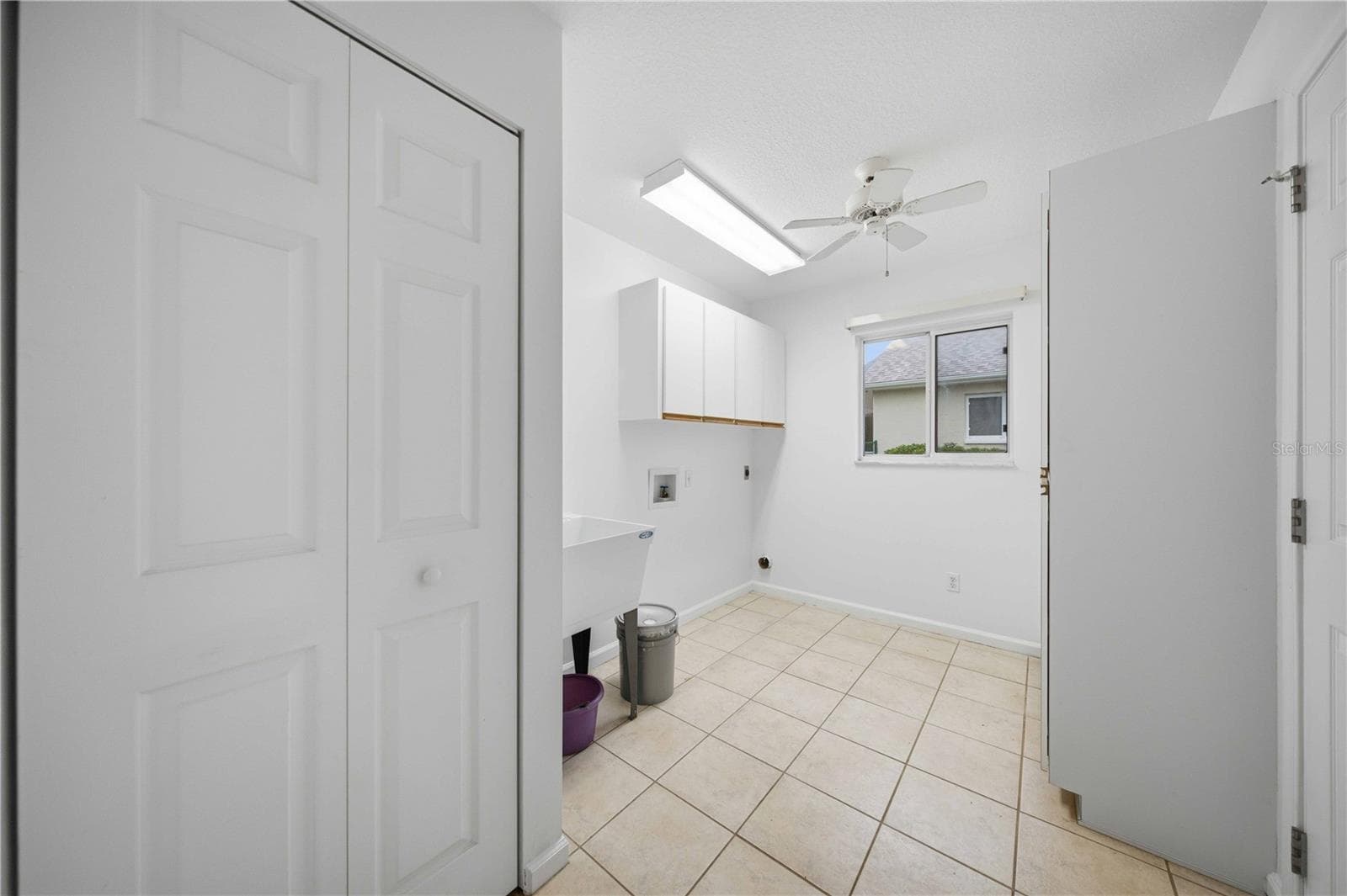 Inside laundry with laundry tub and storage cabinets - 5126 NW 21ST LOOP, OCALA