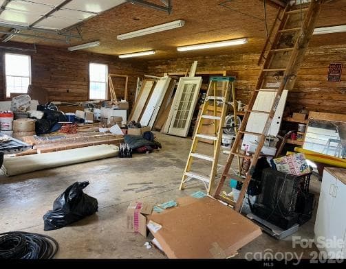 Please overlook the mess as we sort through the estate! Open workspace with continuous workbench with storage, pull-down stairs to access floored attic space - 1211 Sharon School Road, Stony Point