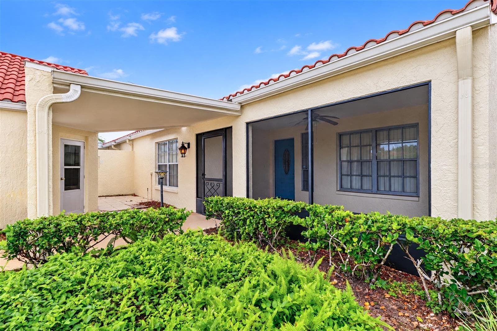 Side view of the covered breezeway and large front screened lanai/porch - 978 MADRID DR, PALM HARBOR
