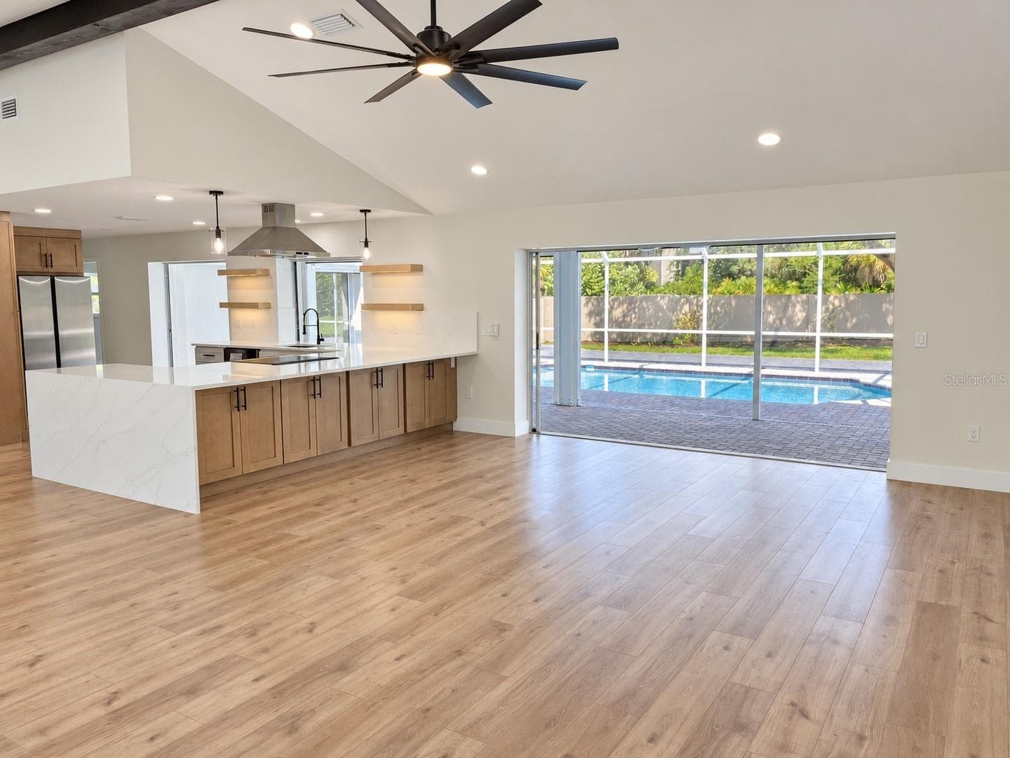 Living area with kitchen and pool access - 102 WINDWARD DR, OSPREY