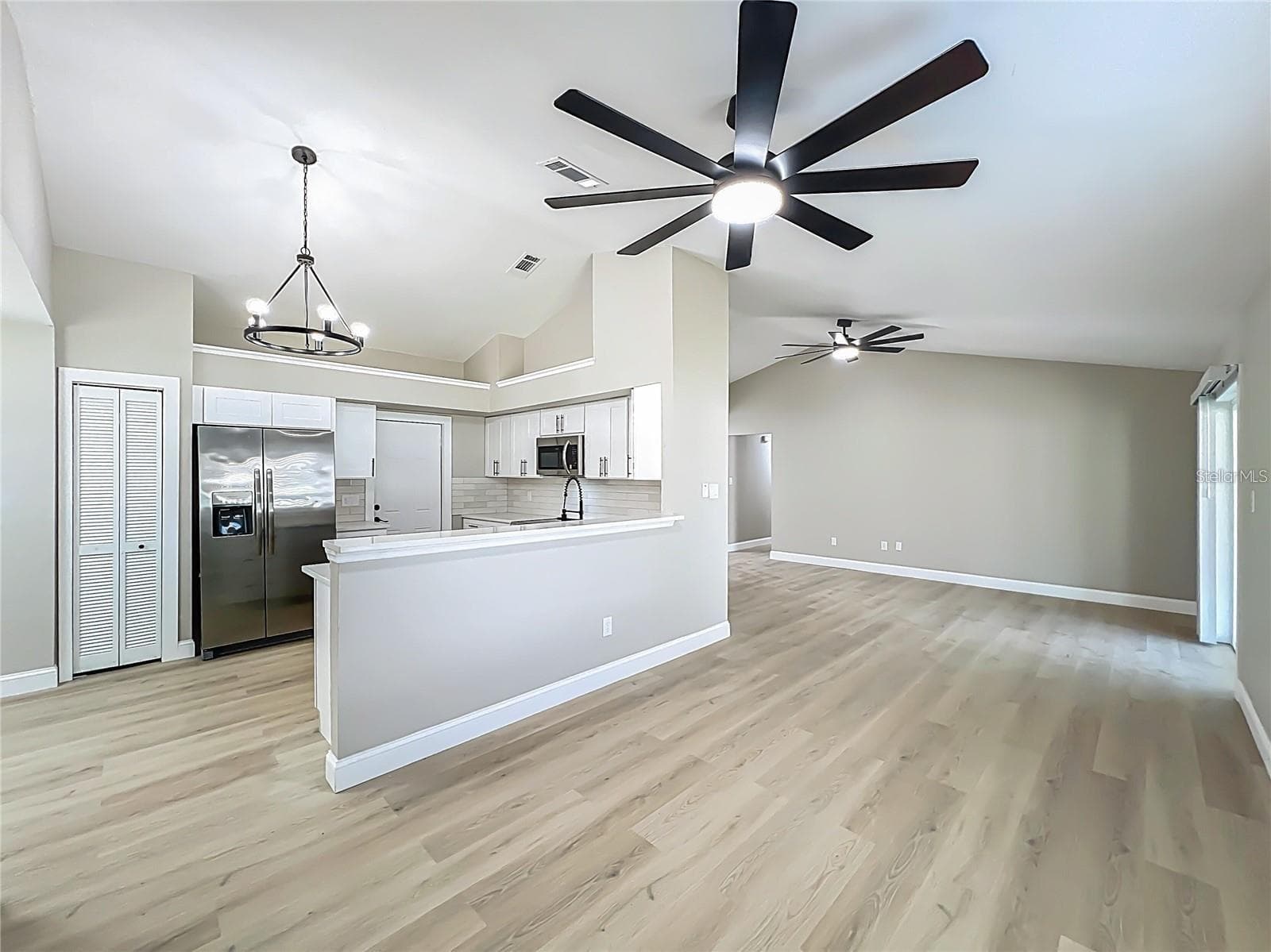 View from dining room area toward kitchen, garage entrance, living room and breezeway. - 6911 CRESCENT RIDGE RD, ORLANDO