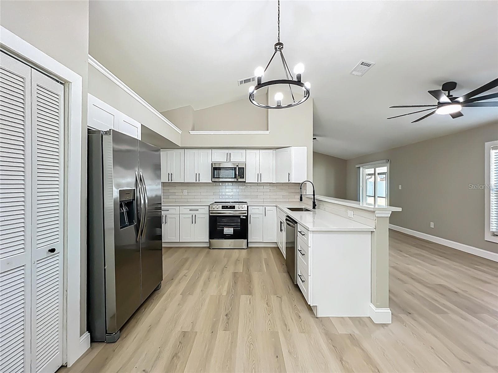 View of kitchen from dinette area toward living room. - 6911 CRESCENT RIDGE RD, ORLANDO