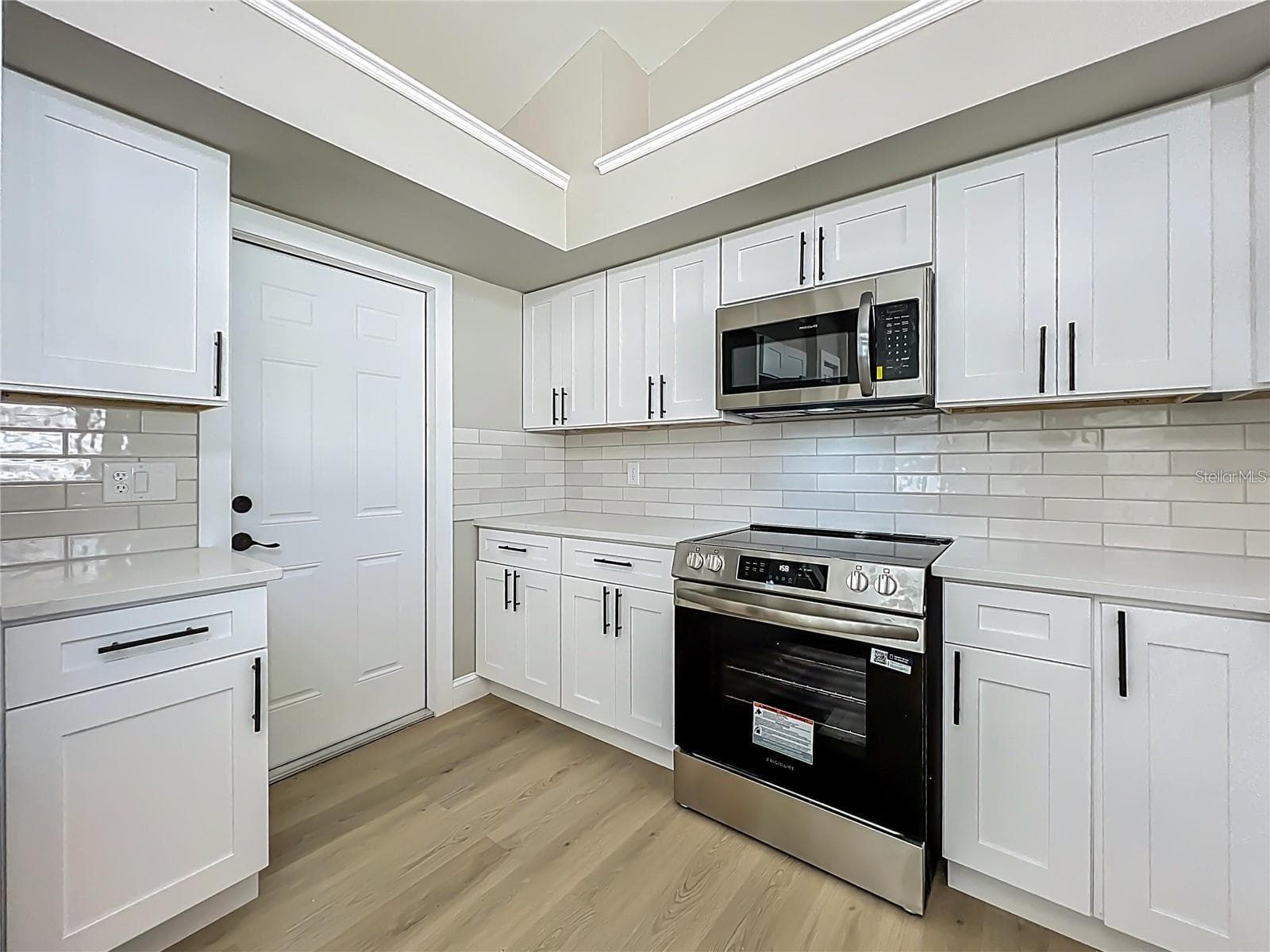 View of kitchen toward garage exit door way. - 6911 CRESCENT RIDGE RD, ORLANDO