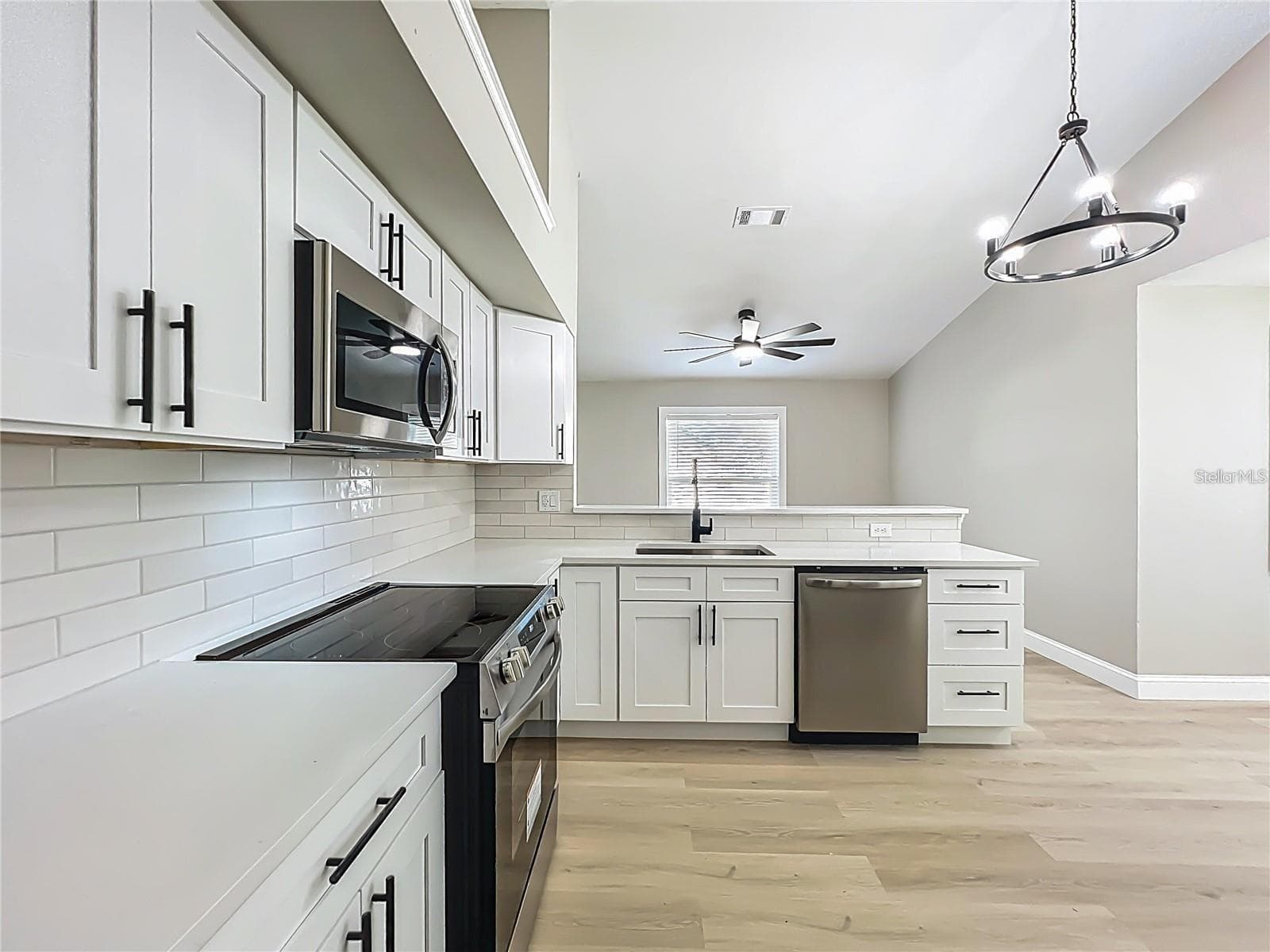 View of kitchen from garage exit doorway toward dining room area. - 6911 CRESCENT RIDGE RD, ORLANDO