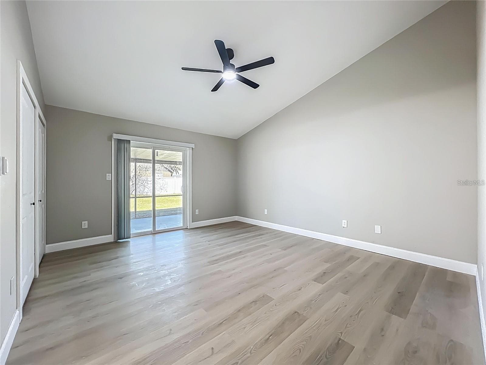 View of primary bedroom from entrance toward sliding doors. - 6911 CRESCENT RIDGE RD, ORLANDO