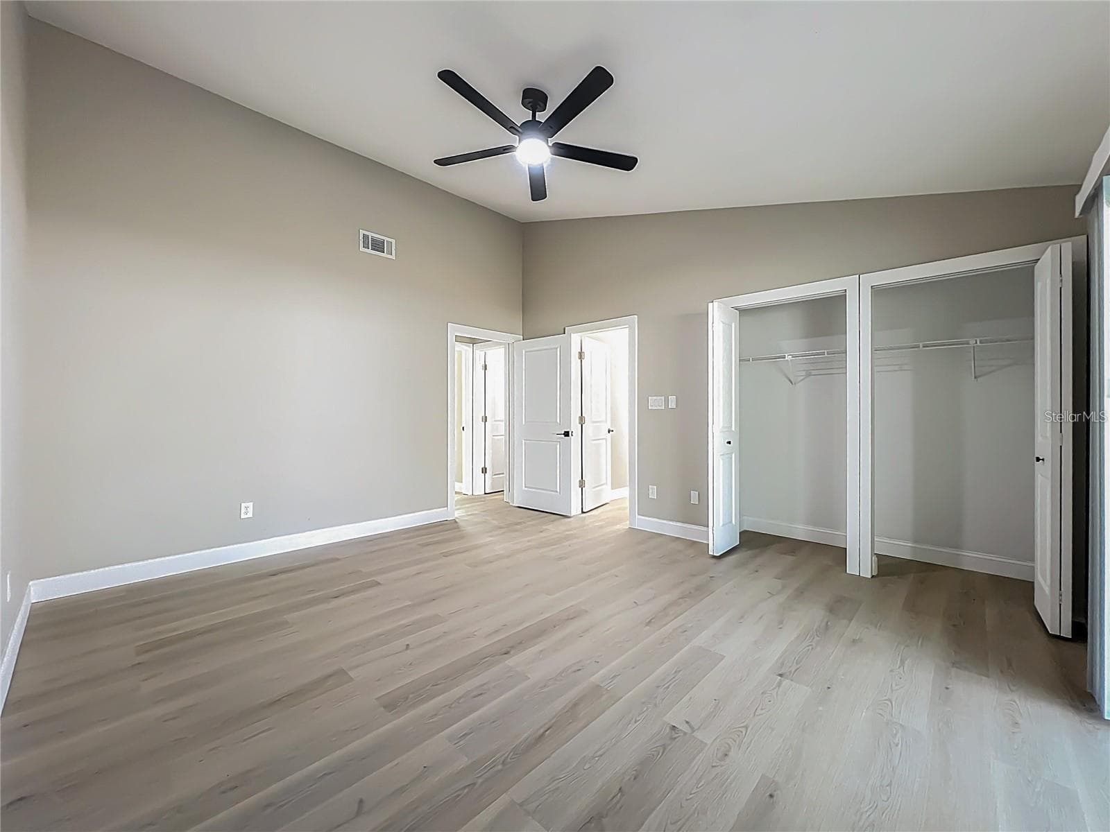 View of primary bedroom double closets, bathroom and entrance. - 6911 CRESCENT RIDGE RD, ORLANDO