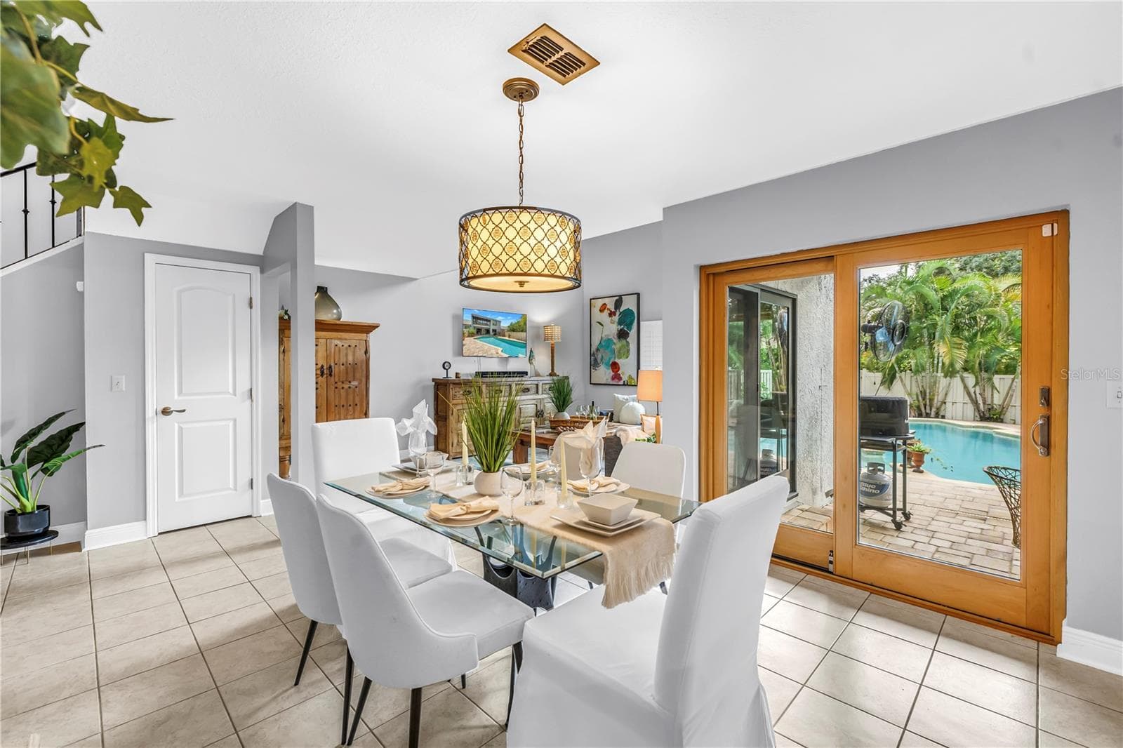 The dining room features panoramic views of the tropical sanctuary, enhanced by premium Pella wood hurricane sliders. - 990 SAN CARLOS CT NE, ST PETERSBURG