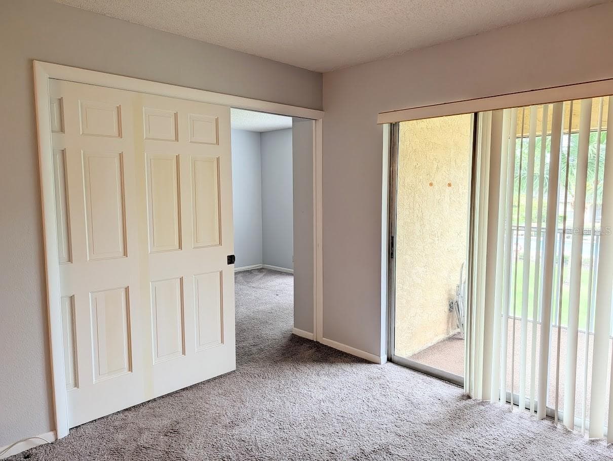 Entry to 2nd bedroom with pocket door partially closed - 8765 BARDMOOR BLVD #207, SEMINOLE