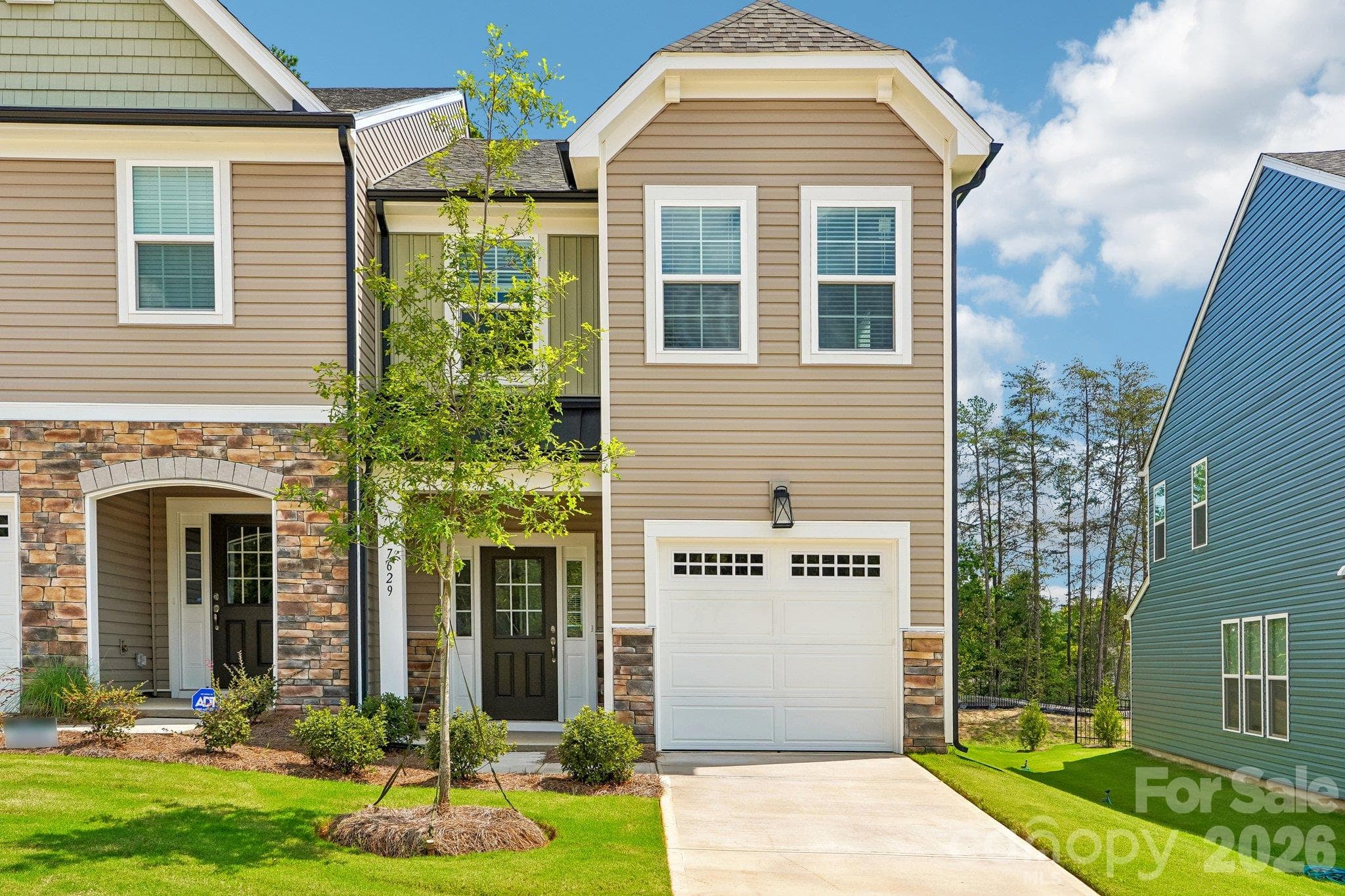 Inviting townhome exterior with an attached garage and charming curb appeal. - Bell Glen, Charlotte