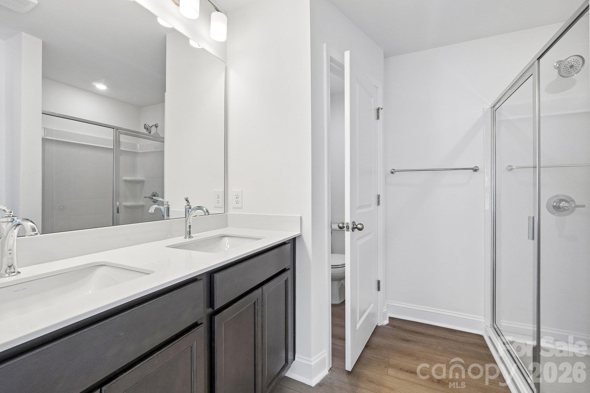 Beautiful bathroom with a dual-sink vanity and glass-enclosed shower. - Bell Glen, Charlotte