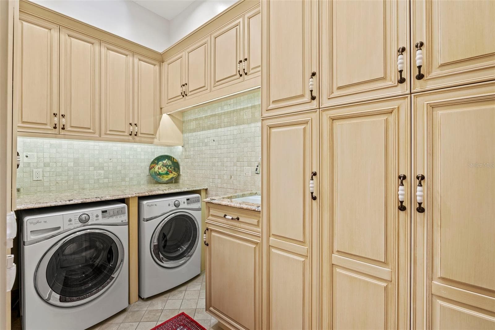 Laundry Room with sink and plenty of custom storage cabinets for cleaning supplies and paper goods. - 964 MONTE CRISTO BLVD, TIERRA VERDE