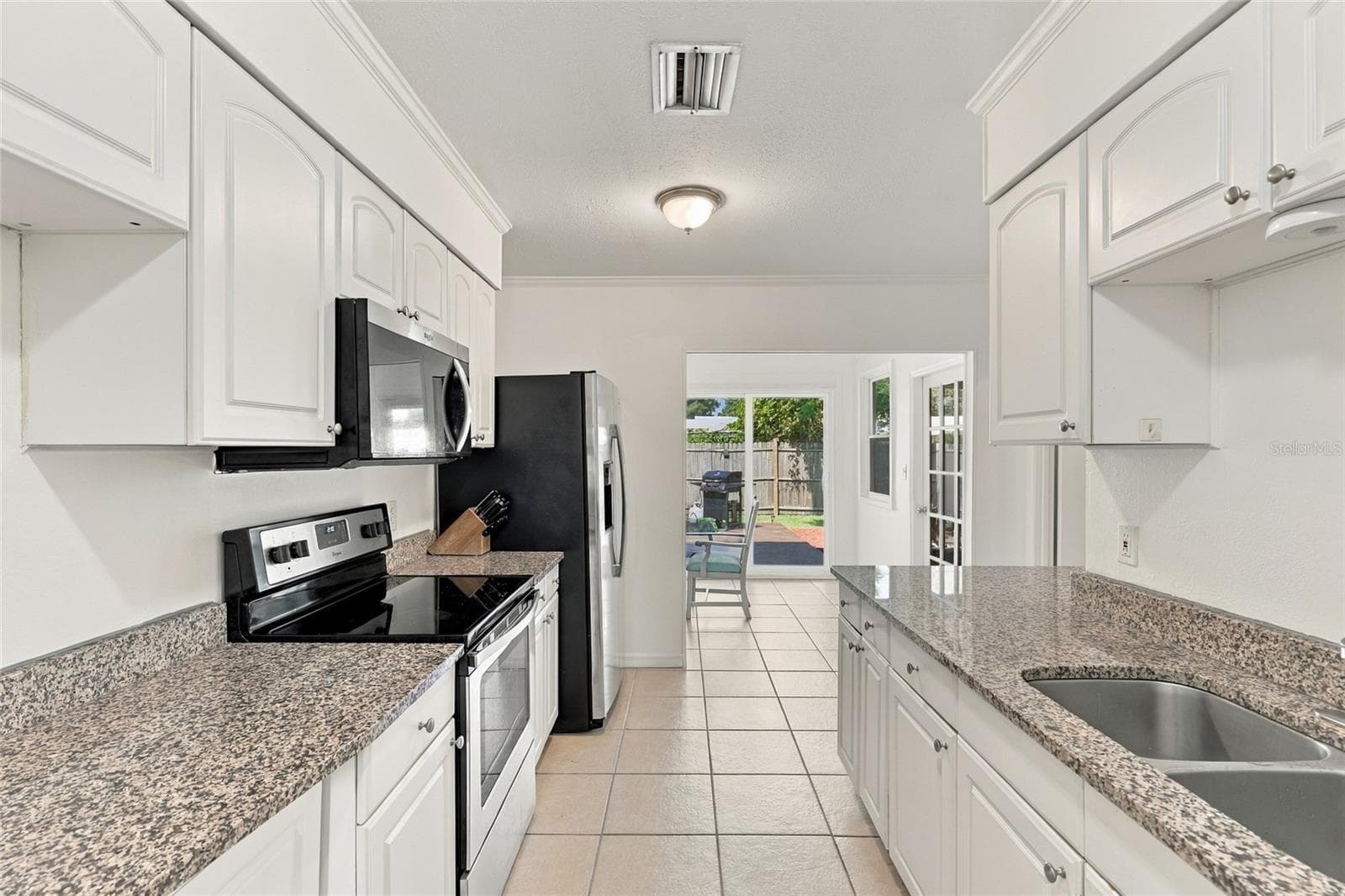 Galley-Style Kitchen Featuring Granite Countertops - 2629 JAMAICA ST #1, SARASOTA