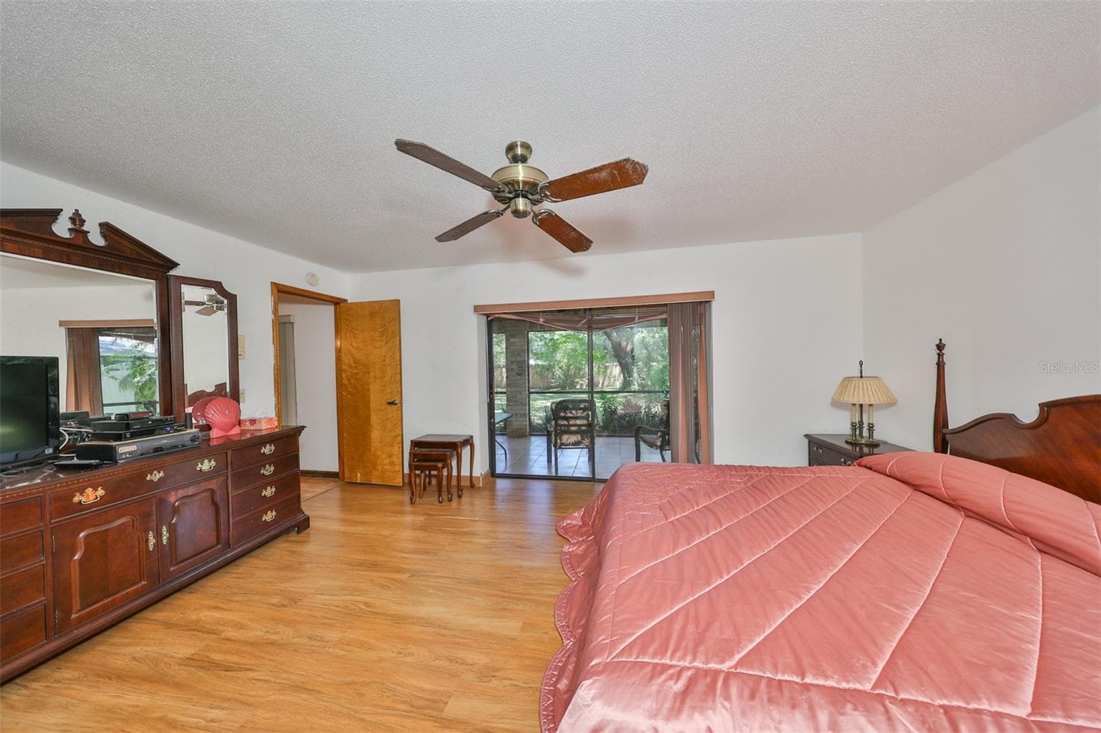 Primary Bedroom has sliding glass doors that lead to the screened lanai. - 2609 MANOR OAK DR, VALRICO