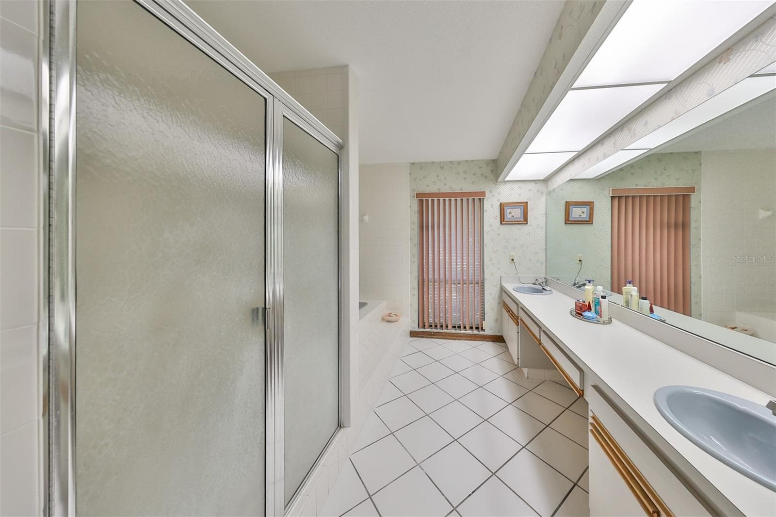 Primary ensuite bathroom with dual sinks, soaking tube, private toilet room and a window for natural sunshine - 2609 MANOR OAK DR, VALRICO