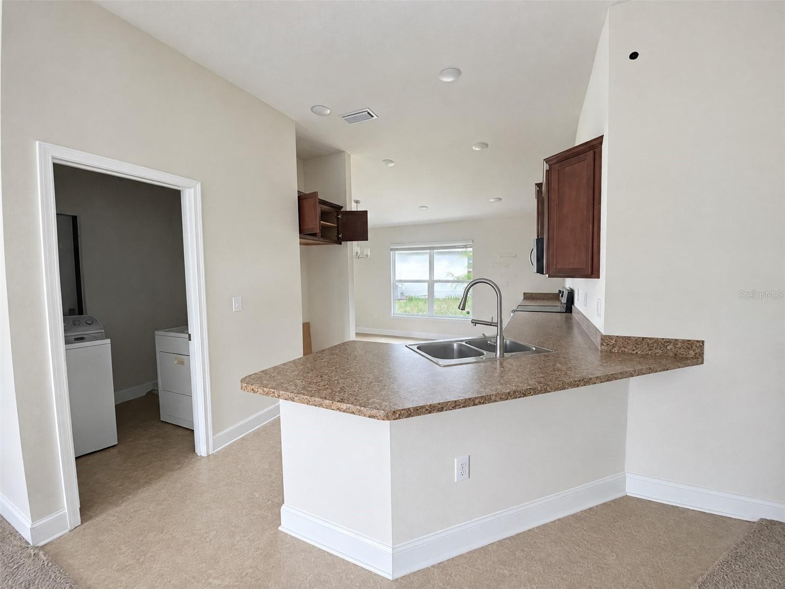 Kitchen, Peninsula with Counter Seating, with Eat in Dining Area. View of Laundry Room. - 2091 PECOS DR, POINCIANA