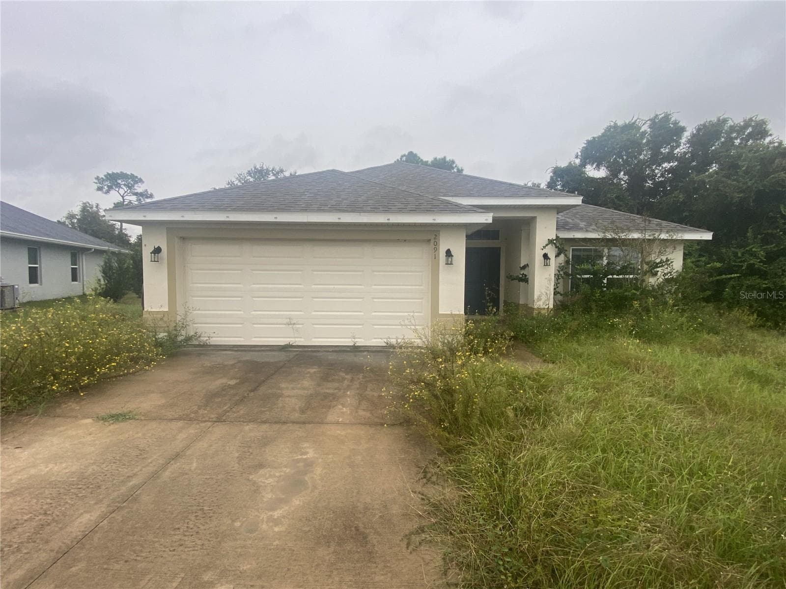 Front View of Home Prior to Grass Cutting. - 2091 PECOS DR, POINCIANA