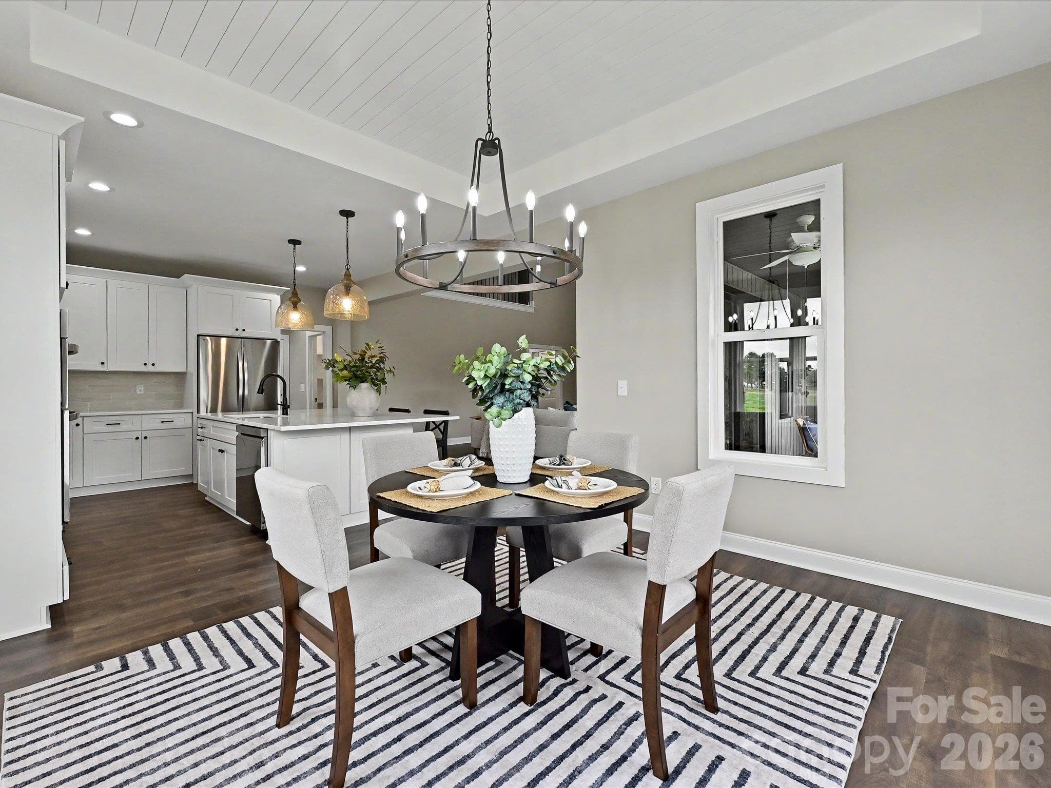 Elegant dining area offers a warm & inviting space to gather, highlighted by designer lighting, tray ceiling detail & seamless flow into the gourmet kitchen. - 159 Lone Pine Road, Statesville