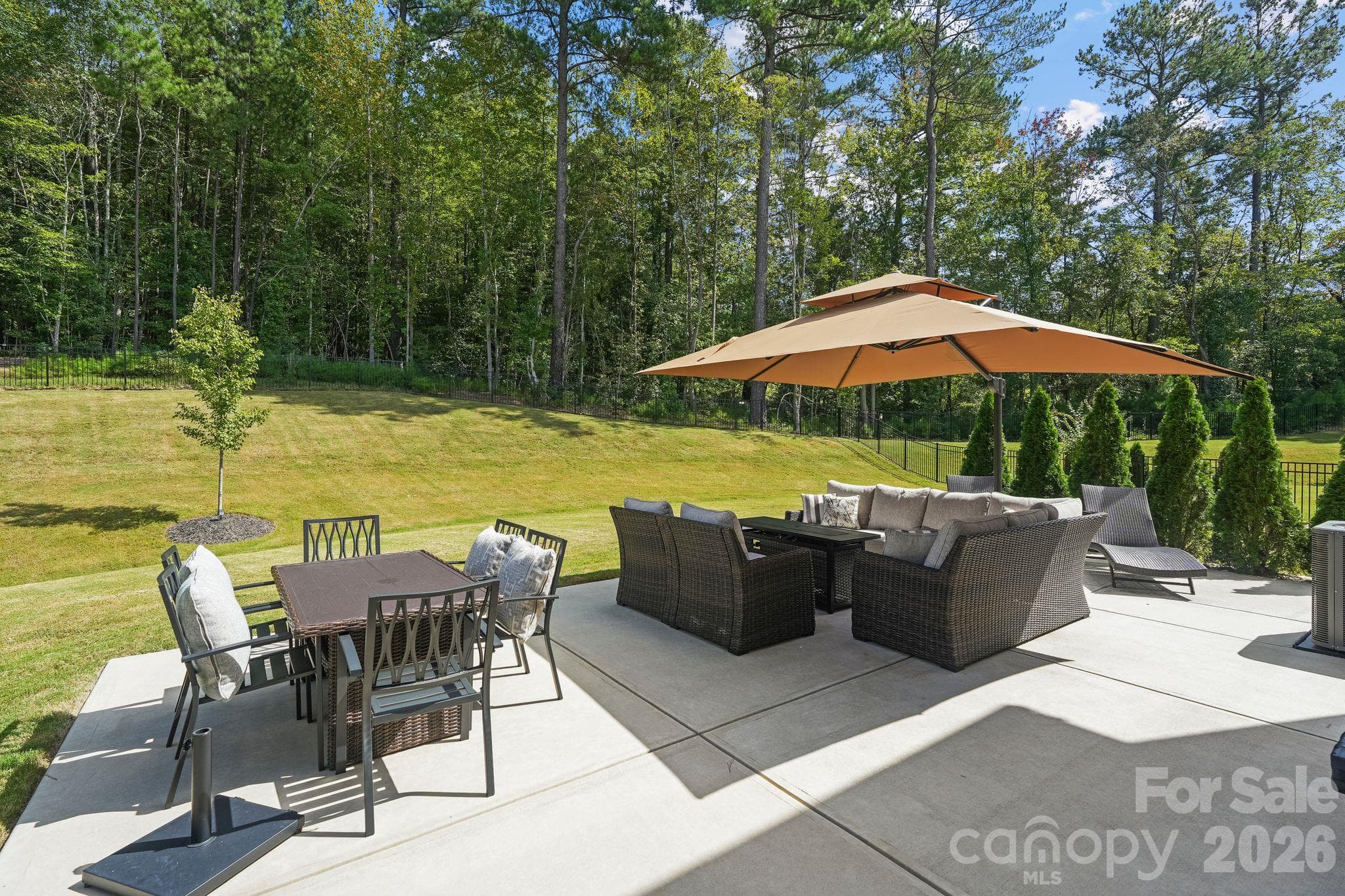 Beautifully landscaped backyard featuring an oversized concrete patio, perfect for outdoor entertaining and relaxation! - 107 Hollywood Court, Troutman