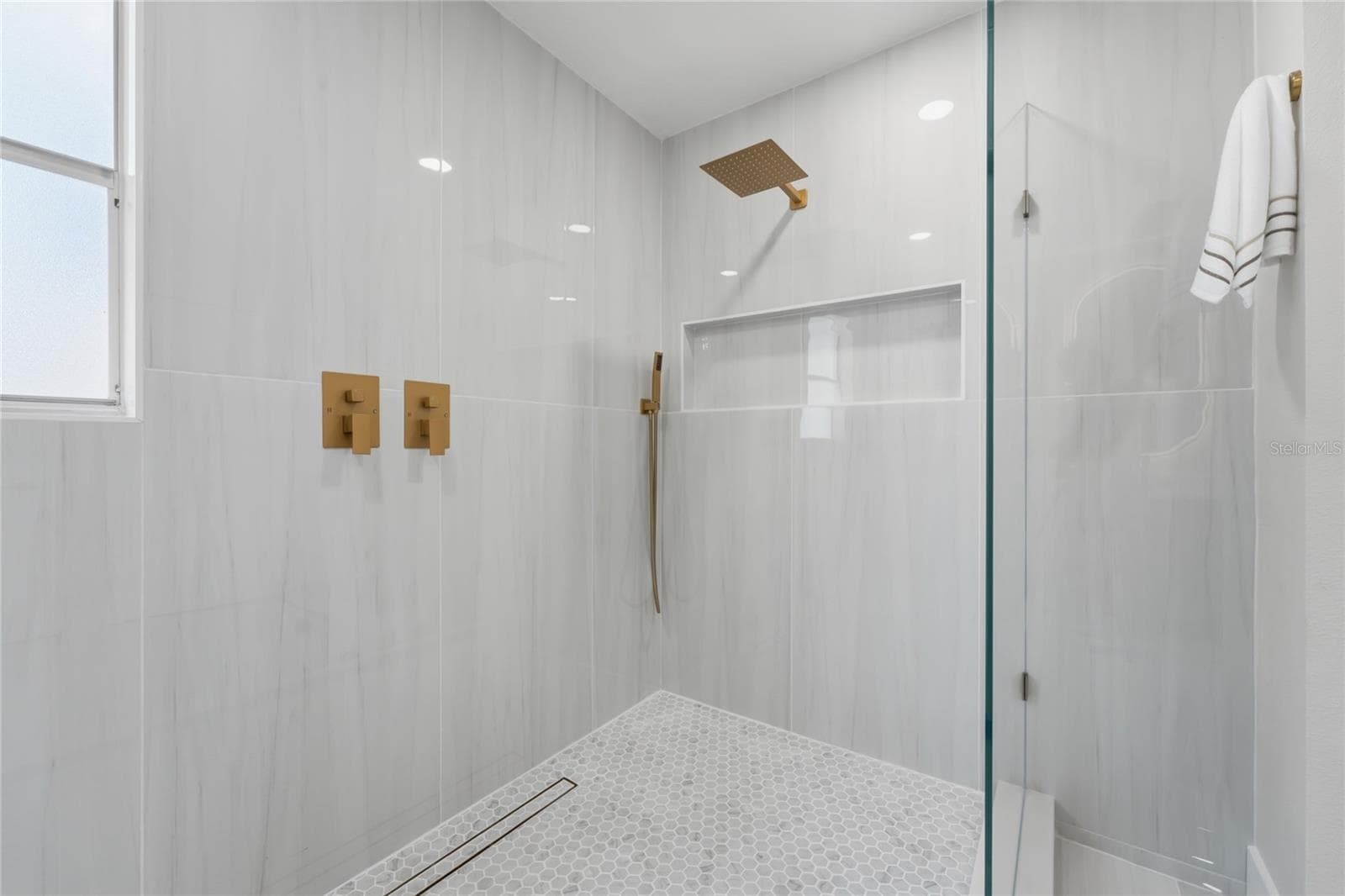 Porcelain tile shower featuring a custom-designed wall niche - 13044 BELLERIVE LN, ORLANDO