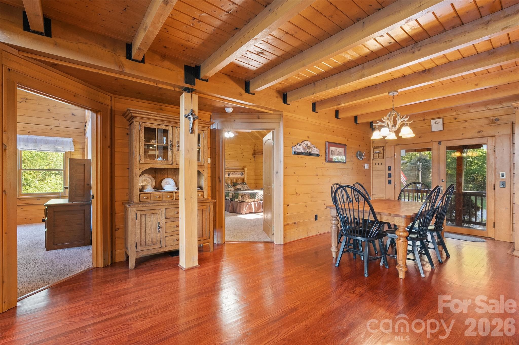 Warm wood interiors, exposed beams, and beautiful hardwood floors throughout the main living areas. - 124 Borges Lane, Waynesville