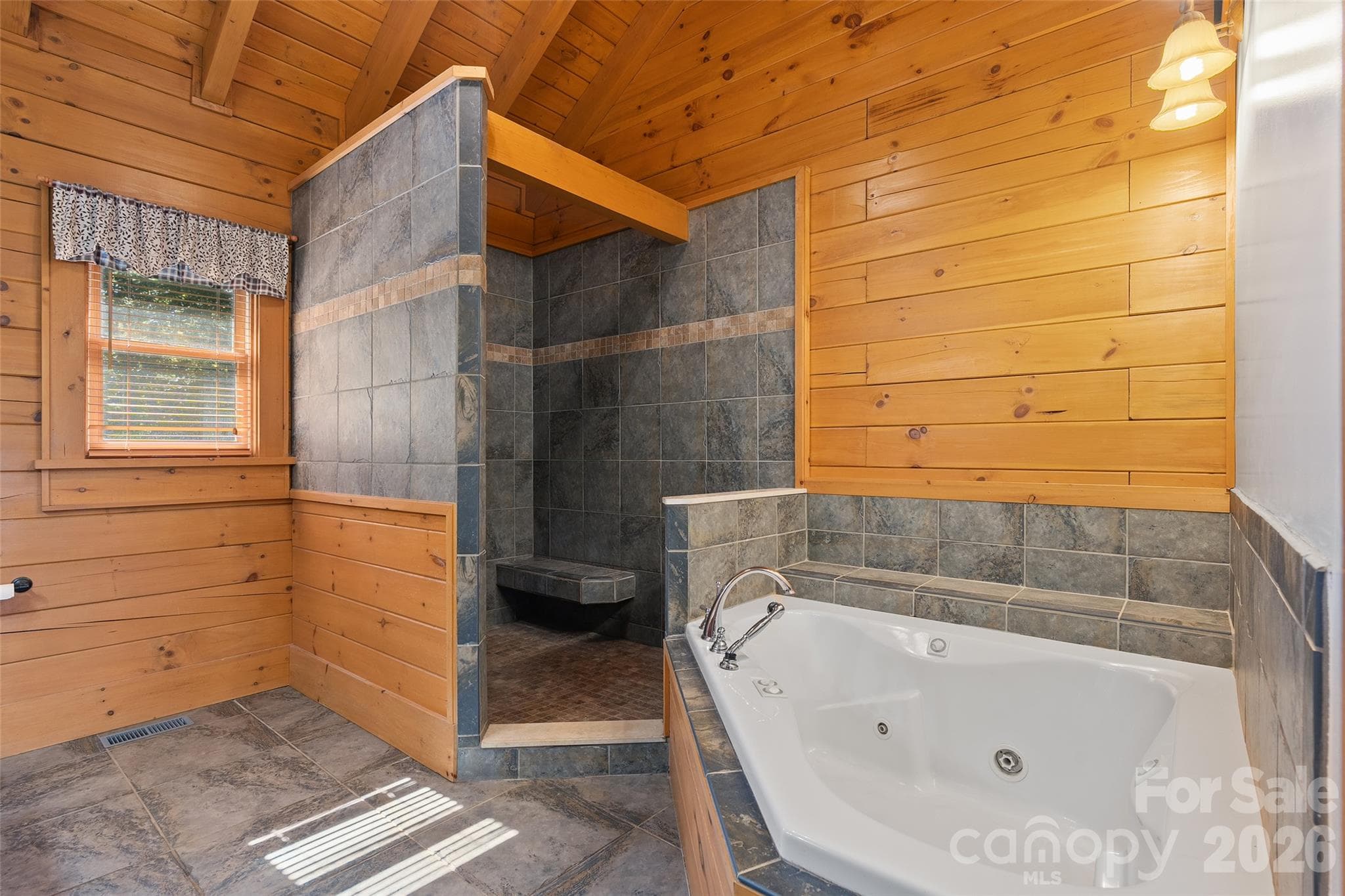 Primary bathroom featuring a jetted soaking tub and tiled walk-in shower. - 124 Borges Lane, Waynesville