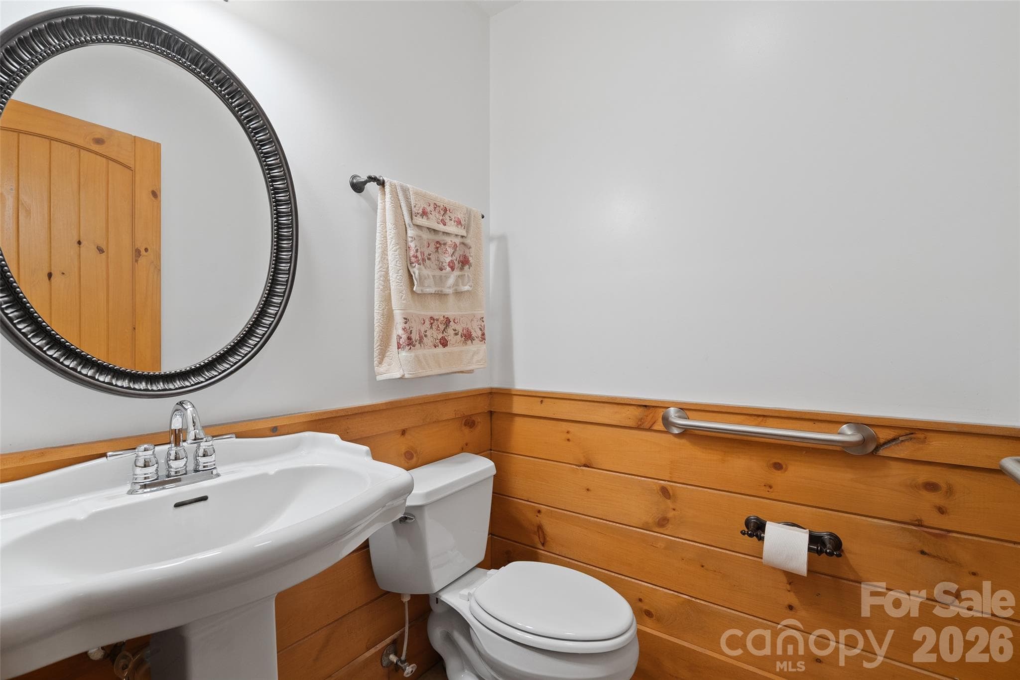 Main-level half bath with pedestal sink and wood accents. - 124 Borges Lane, Waynesville