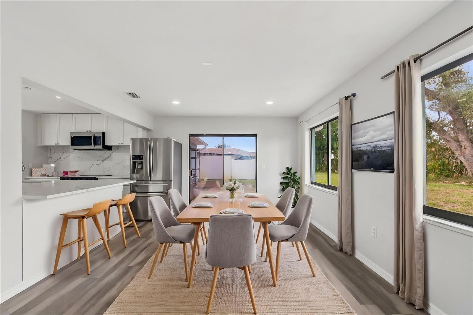 bright and spacious dining area, breakfast bar, natural light and sliding glass doors leading to the outdoor living space - 1023 DEER RUN, VENICE