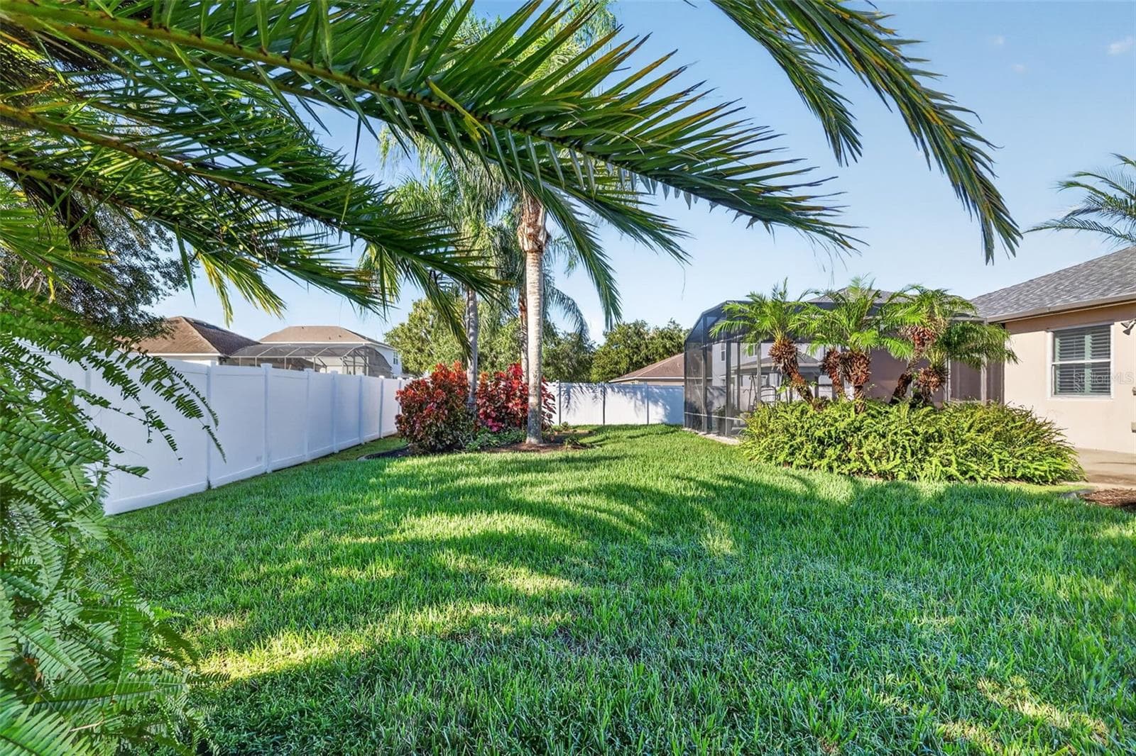 Lush landscaping adds color to the fenced back yard ~ - 4913 ROYCE DR, MOUNT DORA