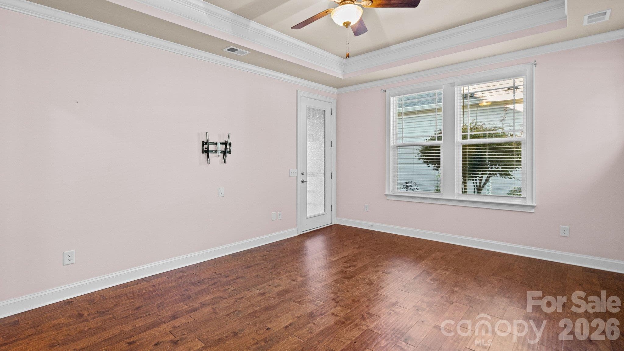 Primary bedroom with tray ceiling and hardwood floors - 2050 Laney Pond Road, Matthews