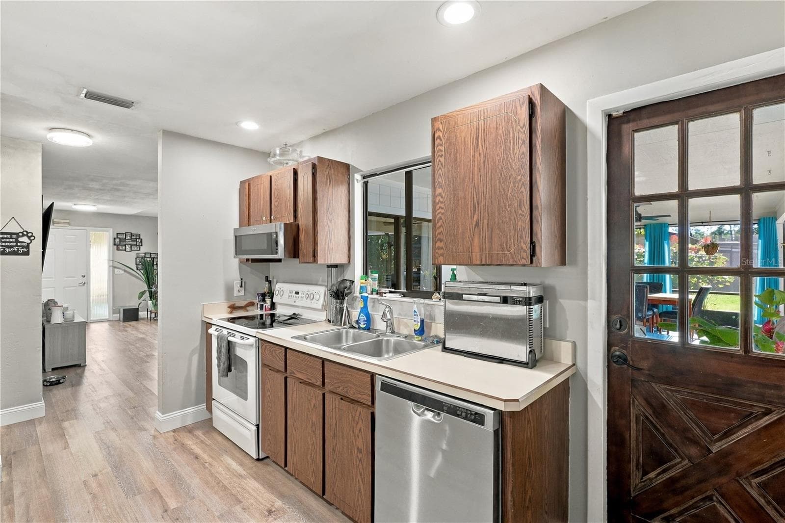 Kitchen View Toward Front Door, Window Overlooks Back Lanai, Door leads to Covered Lanai, Pool & Spa! - 92 FOSTER LN, PALM COAST