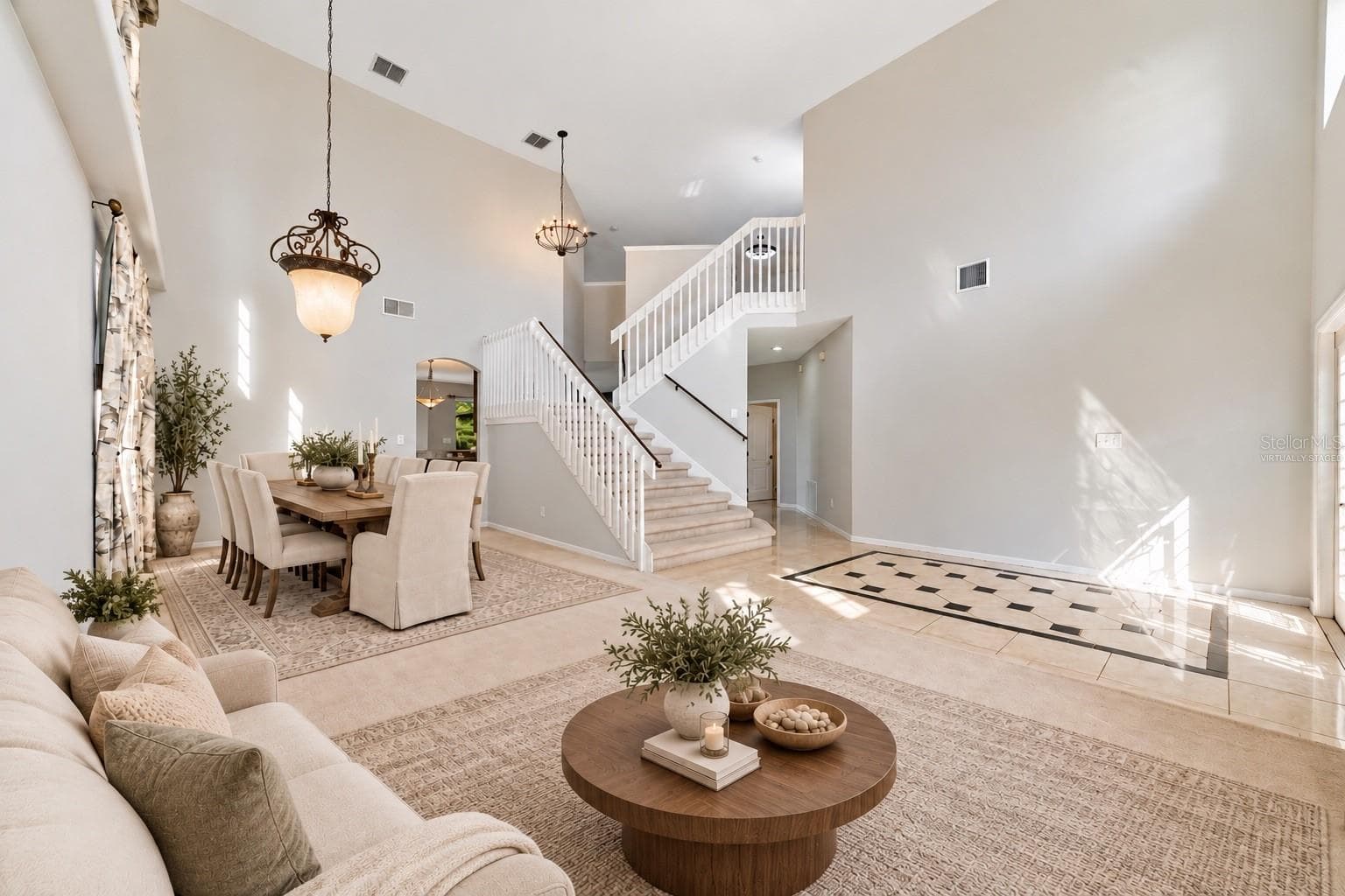 The formal LIVING ROOM/DINING ROOM COMBO share an elegant, open setting enhanced by 2-STORY CEILINGS where a chandelier and decorative ceiling medallion create a lovely atmosphere for hosting holidays and special occasions. Virtually Staged - 1557 AMARYLLIS CIR, ORLANDO