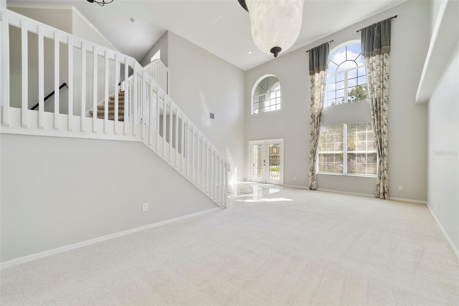 The formal LIVING ROOM/DINING ROOM COMBO share an elegant, open setting enhanced by 2-STORY CEILINGS where a chandelier and decorative ceiling medallion create a lovely atmosphere for hosting holidays and special occasions. - 1557 AMARYLLIS CIR, ORLANDO