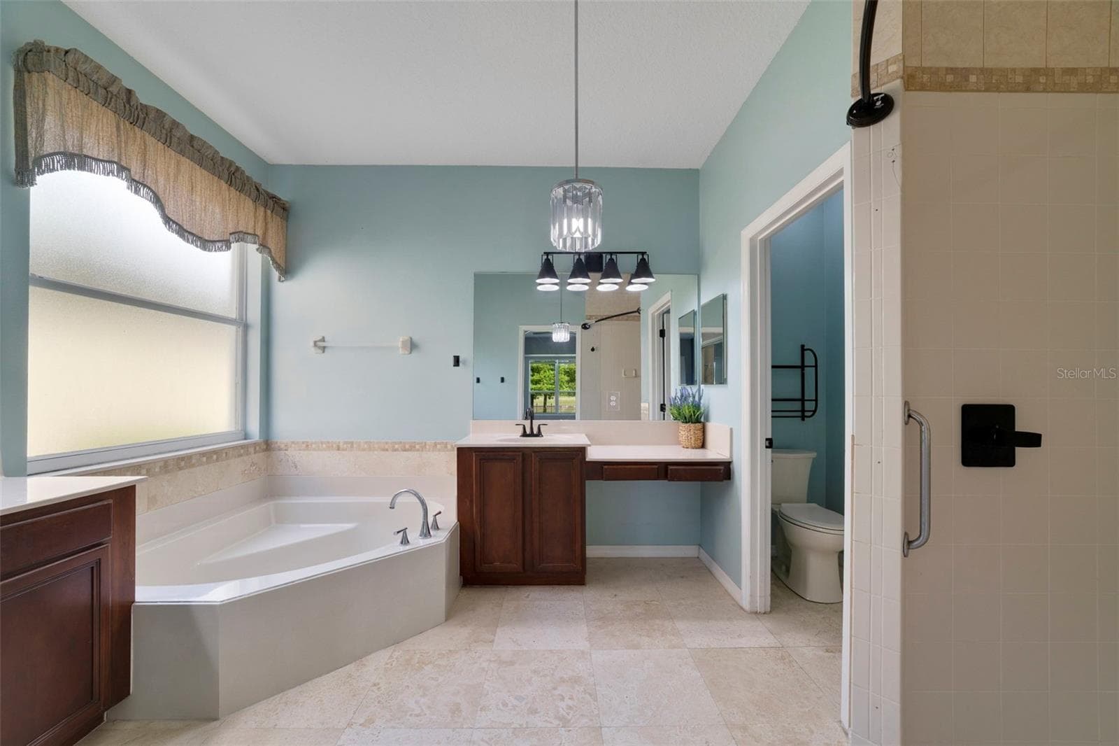The Primary en suite Bath features dual vanities, a RELAXING GARDEN TUB, a step-in shower and a private water closet. - 1557 AMARYLLIS CIR, ORLANDO