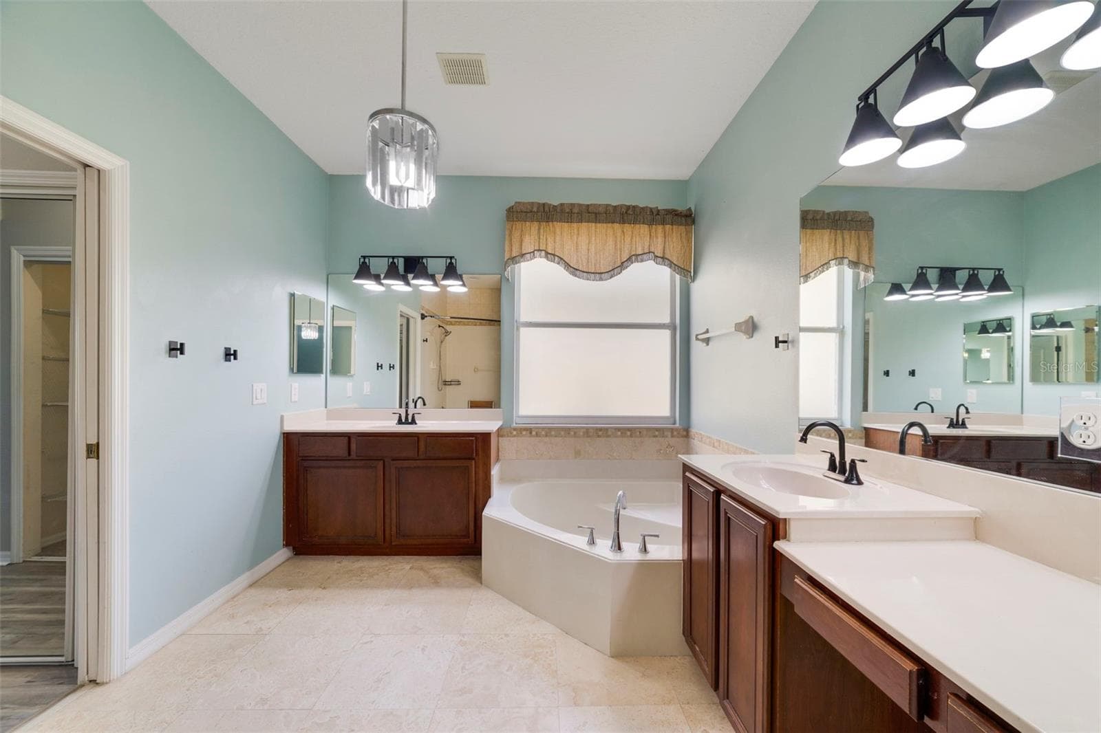The Primary en suite Bath features dual vanities, a RELAXING GARDEN TUB, a step-in shower and a private water closet. - 1557 AMARYLLIS CIR, ORLANDO