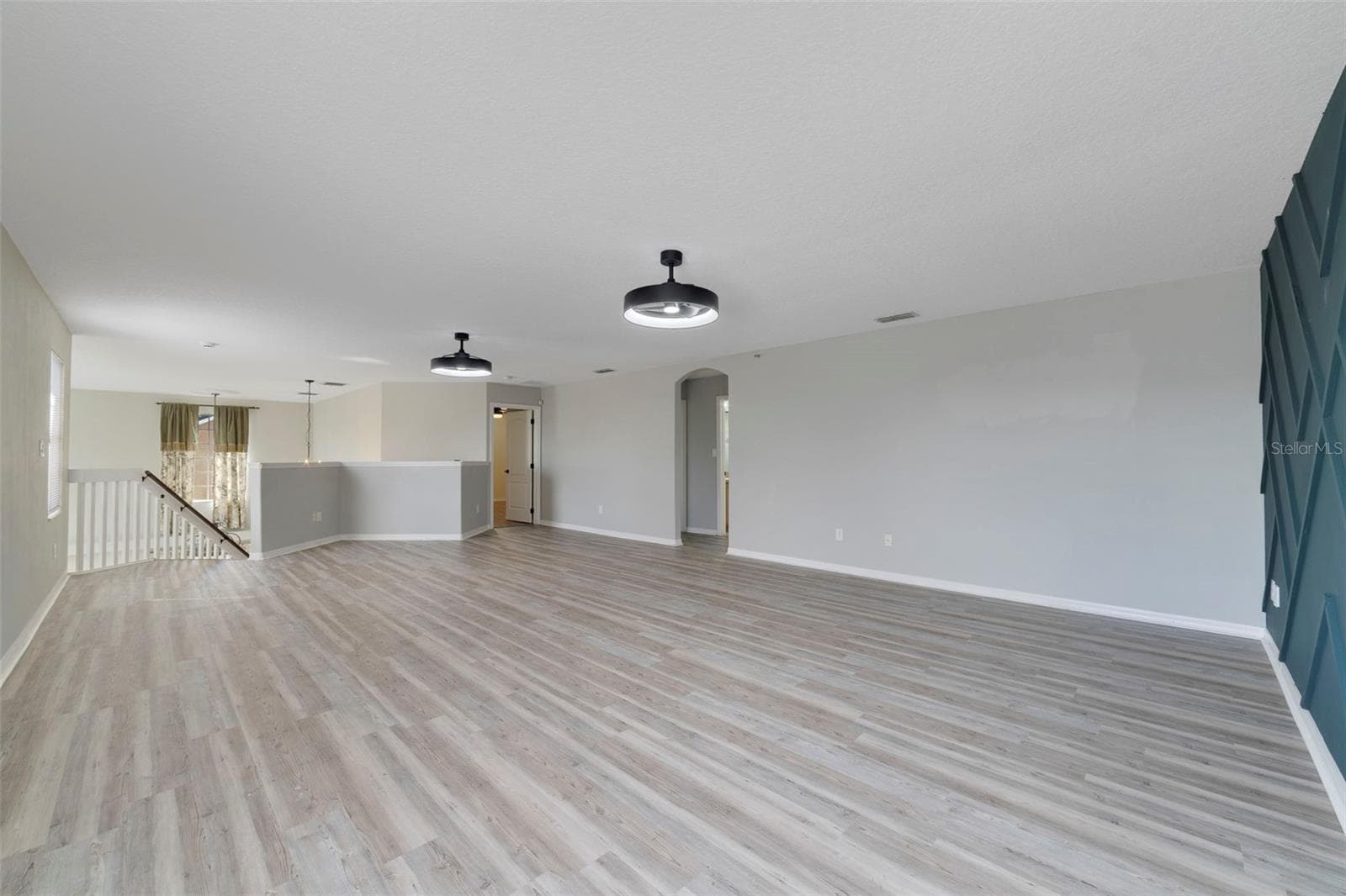 Upstairs, a HUGE LOFT with UPDATED LIGHT/FAN FIXTURES and an accent wall, provides valuable flex space for a media room, game room, home office or additional lounge area. - 1557 AMARYLLIS CIR, ORLANDO