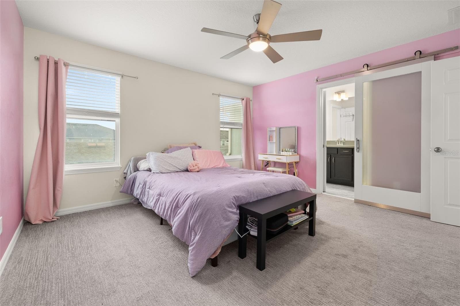 Primary suite with a custom barn door leading to the primary bathroom - 8067 GLENLLOYD AVE, WINTER GARDEN