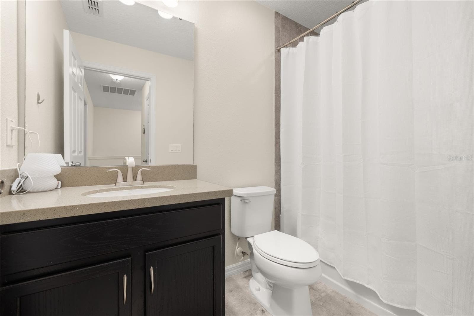 Secondary bathroom near bedrooms 2 and 3 upstairs featuring a shower/bathtub combination - 8067 GLENLLOYD AVE, WINTER GARDEN
