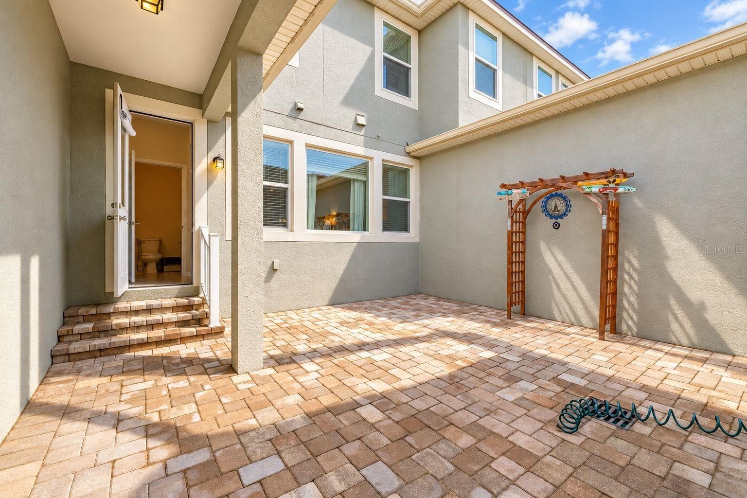 Private brick-paved courtyard between the house and the 2-car garage - 8067 GLENLLOYD AVE, WINTER GARDEN