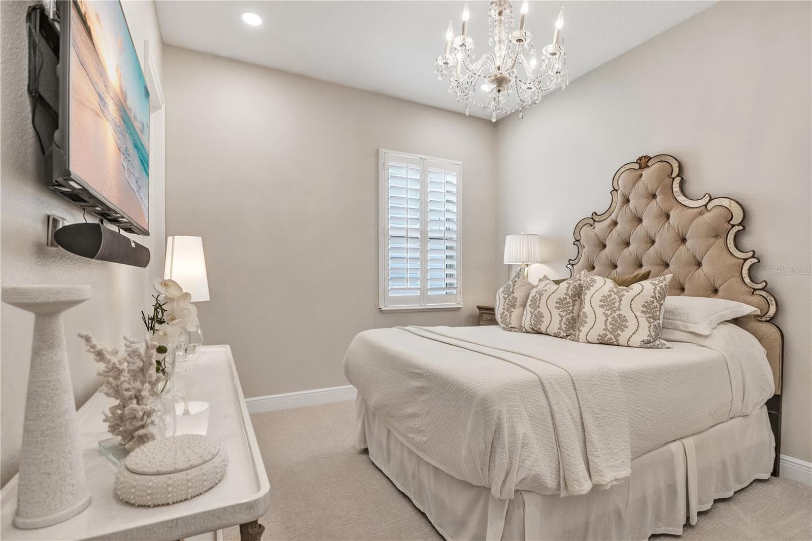 Beautifully appointed bedroom featuring a crystal-style chandelier and plantation shutters. - 15749 CUTTER SAIL PL, WINTER GARDEN