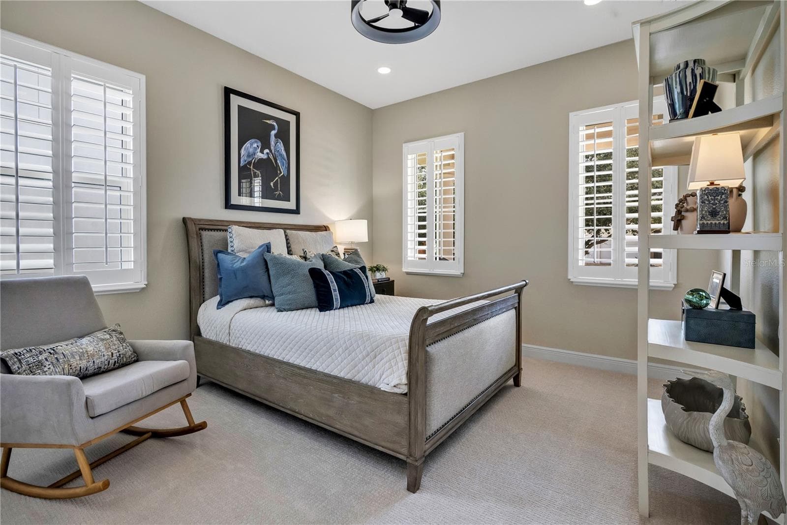 Inviting bedroom with plantation shutters and natural light from multiple windows. - 15749 CUTTER SAIL PL, WINTER GARDEN