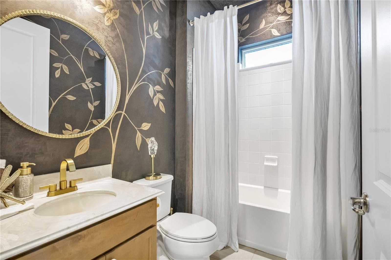 Beautifully styled bathroom featuring decorative wall finishes and elegant gold accents. - 15749 CUTTER SAIL PL, WINTER GARDEN