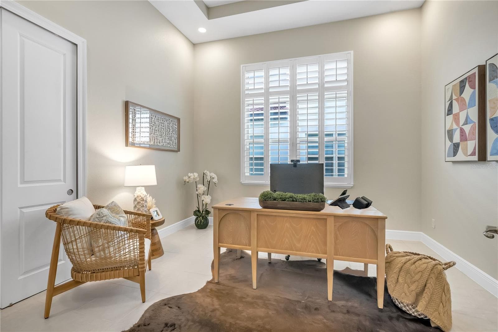 Dedicated home office featuring a tray ceiling, plantation shutters, and natural light. - 15749 CUTTER SAIL PL, WINTER GARDEN