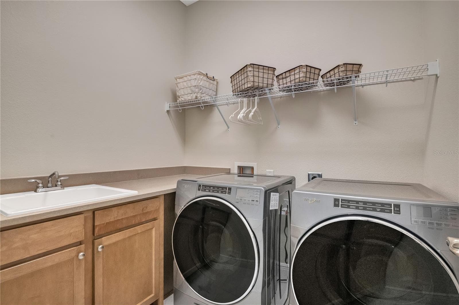Spacious laundry room with utility sink, cabinetry, and convenient storage. - 15749 CUTTER SAIL PL, WINTER GARDEN