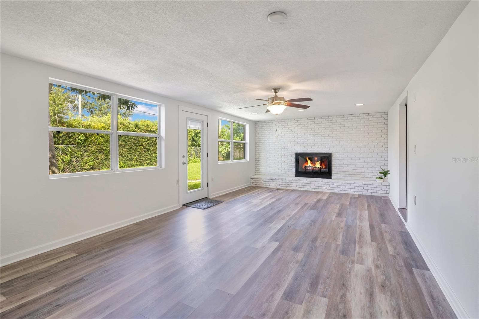 Family Room with wood-burning fireplace leading to backyard - 4415 HAYLOCK DR, ORLANDO